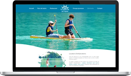 Présentation d'un site web d'une plage à Aiguebelette. Un photo de personnes qui font du paddle illustre l'une des nombreuses activitées proposées par cette entreprise.